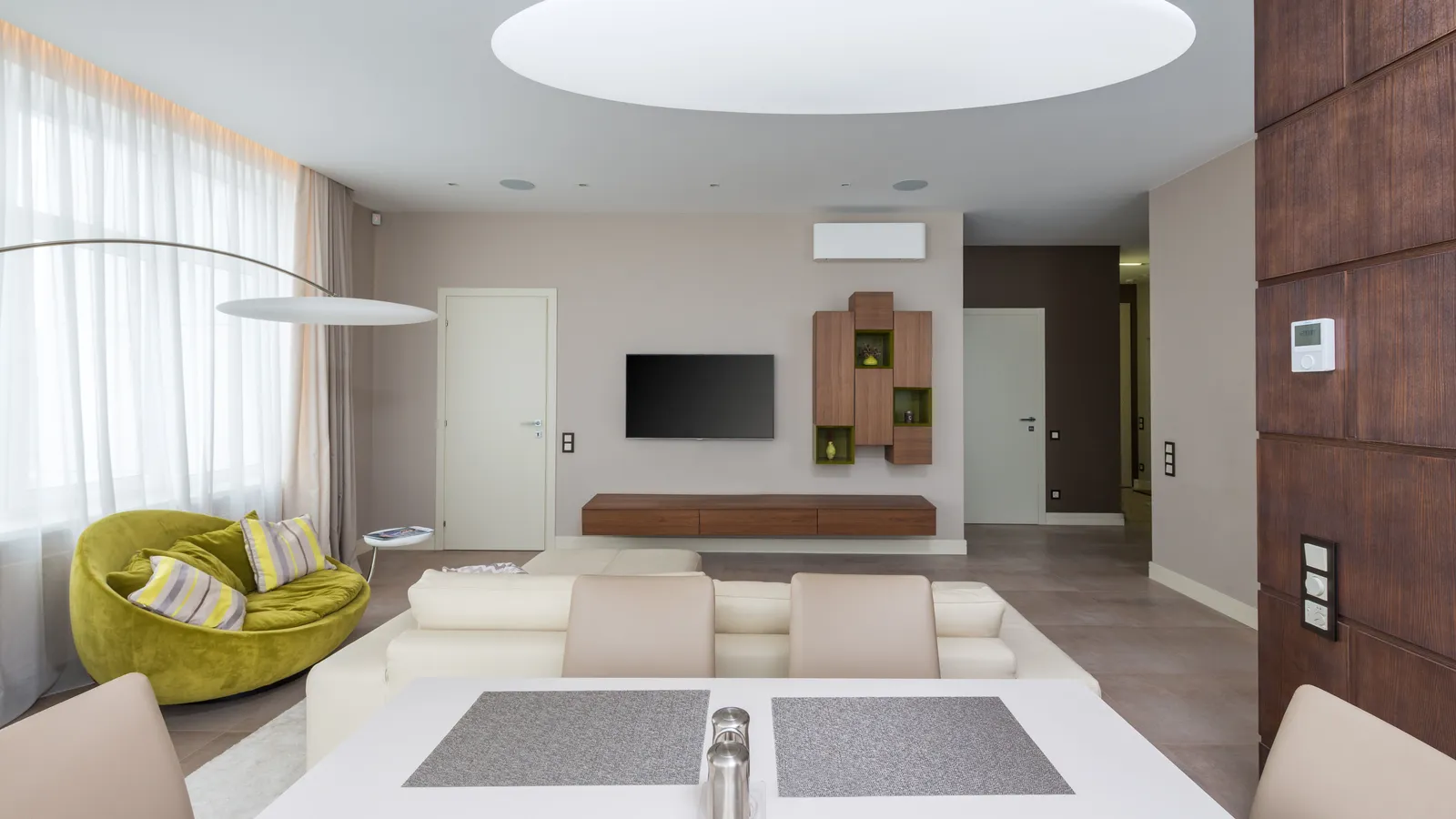Open-plan living room with a white ductless wall unit above the TV wall and a hallway to other rooms, one zone of a three zone DIY mini split setup