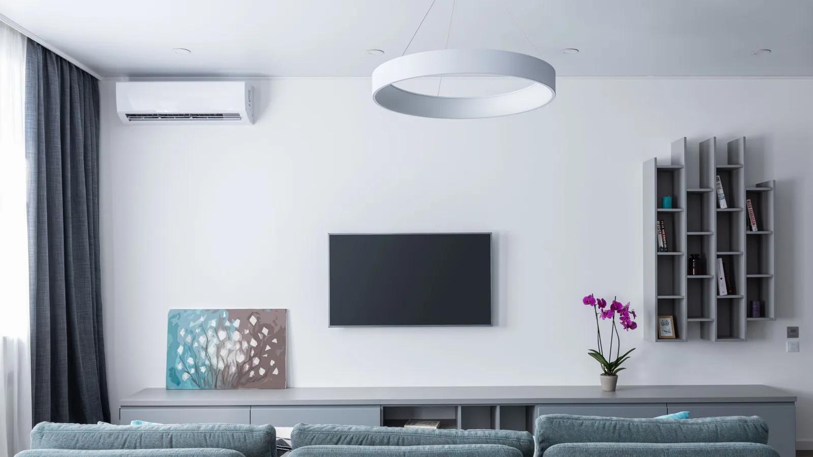 DIY mini split heat pump: white wall-mounted ductless indoor unit installed high on a living room wall, providing both air conditioning and heating