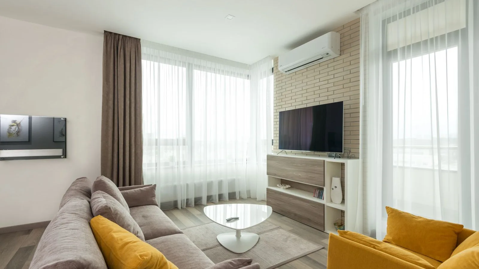 Best DIY mini split with pre-charged line set: wall-mounted ductless indoor unit on a brick wall in a living room, the single-zone head that MrCool, Pioneer and Zone Air systems connect with a line set