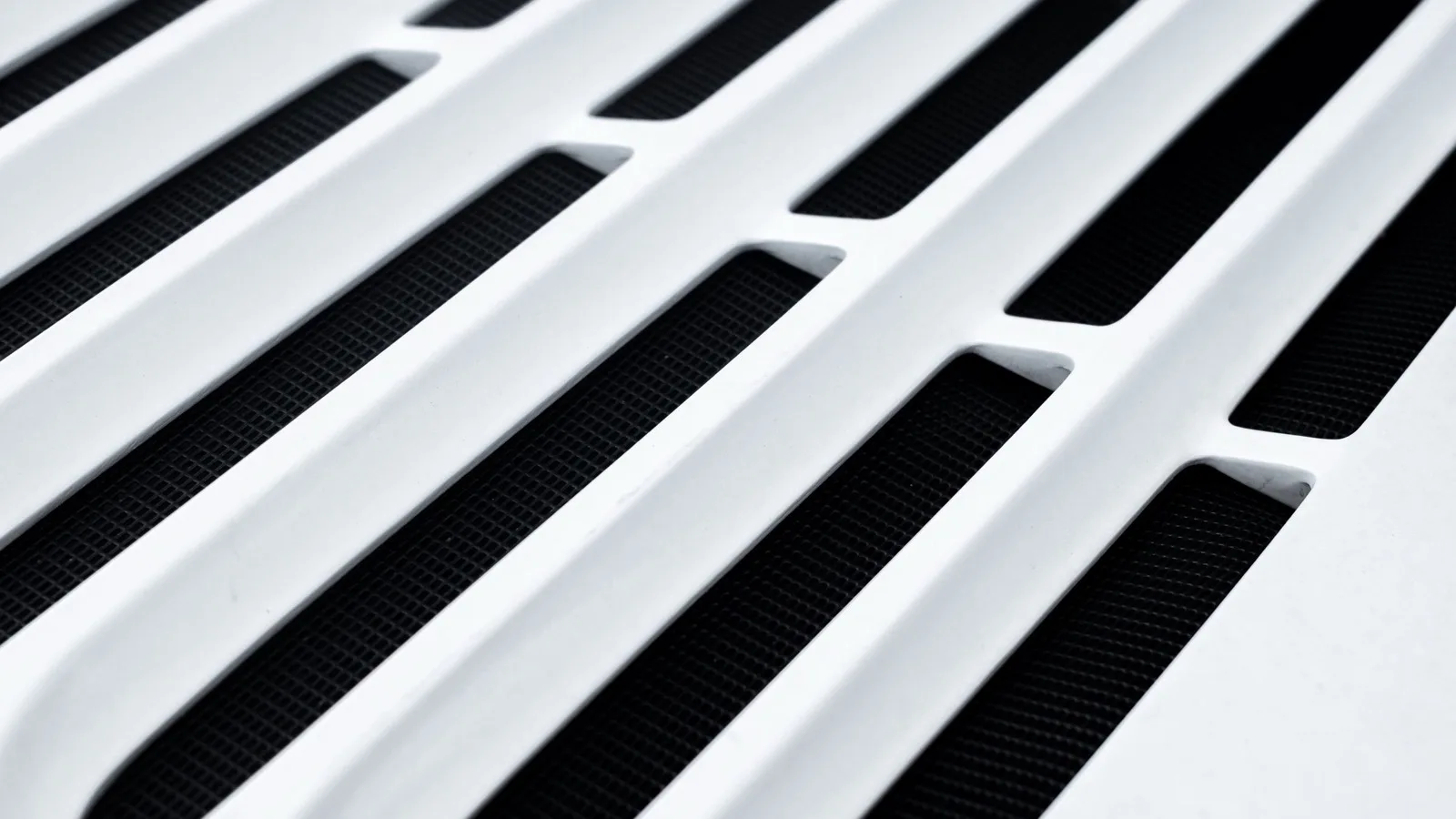 White ceiling supply grille of a concealed duct mini split, the only visible part of the system once the slim ducted air handler is hidden in the ceiling cavity