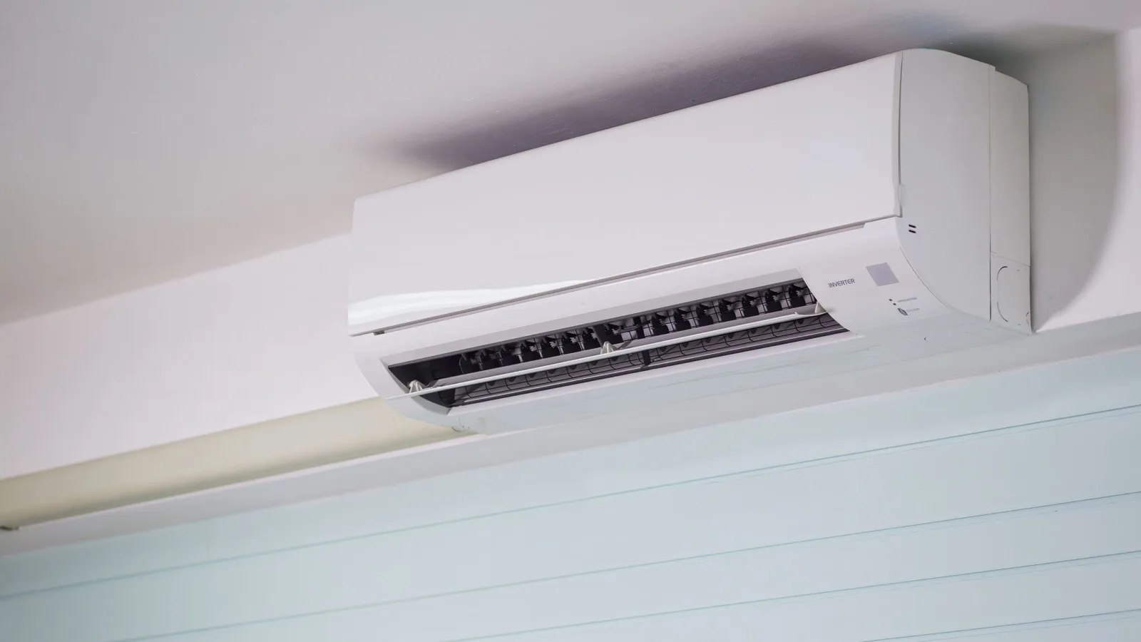Quick connect mini split: close-up of a white wall-mounted ductless inverter indoor unit with its louver open, the kind of head a pre-charged quick connect line set attaches to