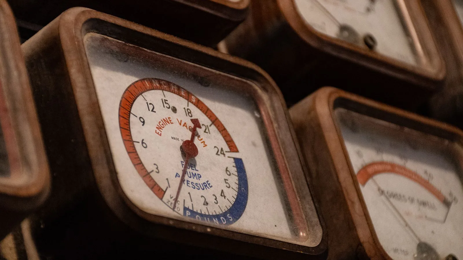 Close-up of an old analog vacuum gauge with a dial marked in inches, the kind of coarse scale that cannot confirm a deep vacuum in microns